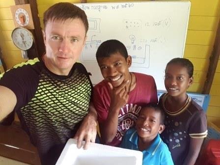 Philip with three of the boys in front of a whiteboard during a home-school lesson