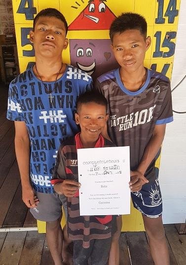 Three of the boys proudly holding up a certificate at the learning centre