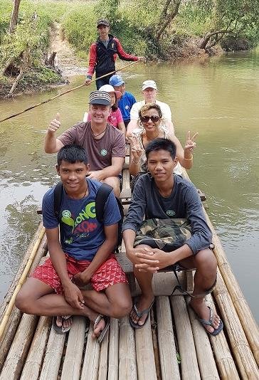 Philip and the boys on a bamboo raft on a river during the trip north