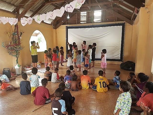 The village gathered in the decorated church to watch the nativity film at Christmas