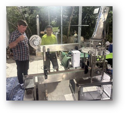 Philip with a technician beside the new bottling machine in the water-and-ice factory