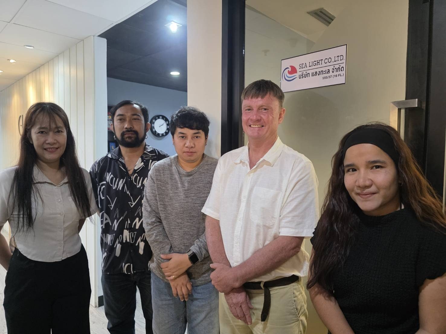 Five adults beside the Sea Light Co., Ltd. office door in Bangkok, photographed during Philip's yearly visa extension